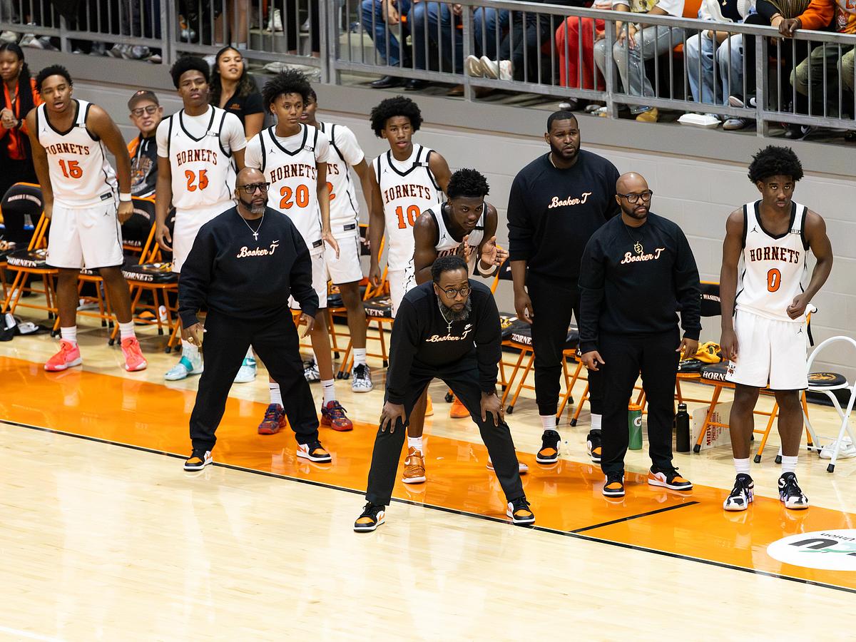 Booker T. Washington Coach Eli K. Brown III stands surrounded by his staff and players during a Jan. 17, 2026, game against Millwood High School.