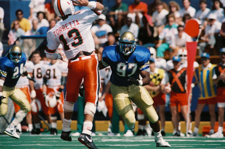 Tulsa's Tracy Scroggins (#97) pressures Miami quarterback Gino Torretta during a game at Skelly Stadium in Tulsa in September 1991.