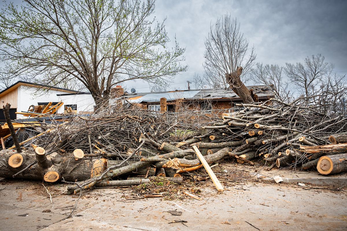 Tree branches and trunks sit outside a home in north Tulsa March 7, 2026. The neighborhood was damaged due to a severe storm believed to be a tornado. Community support groups helped deliver aid.