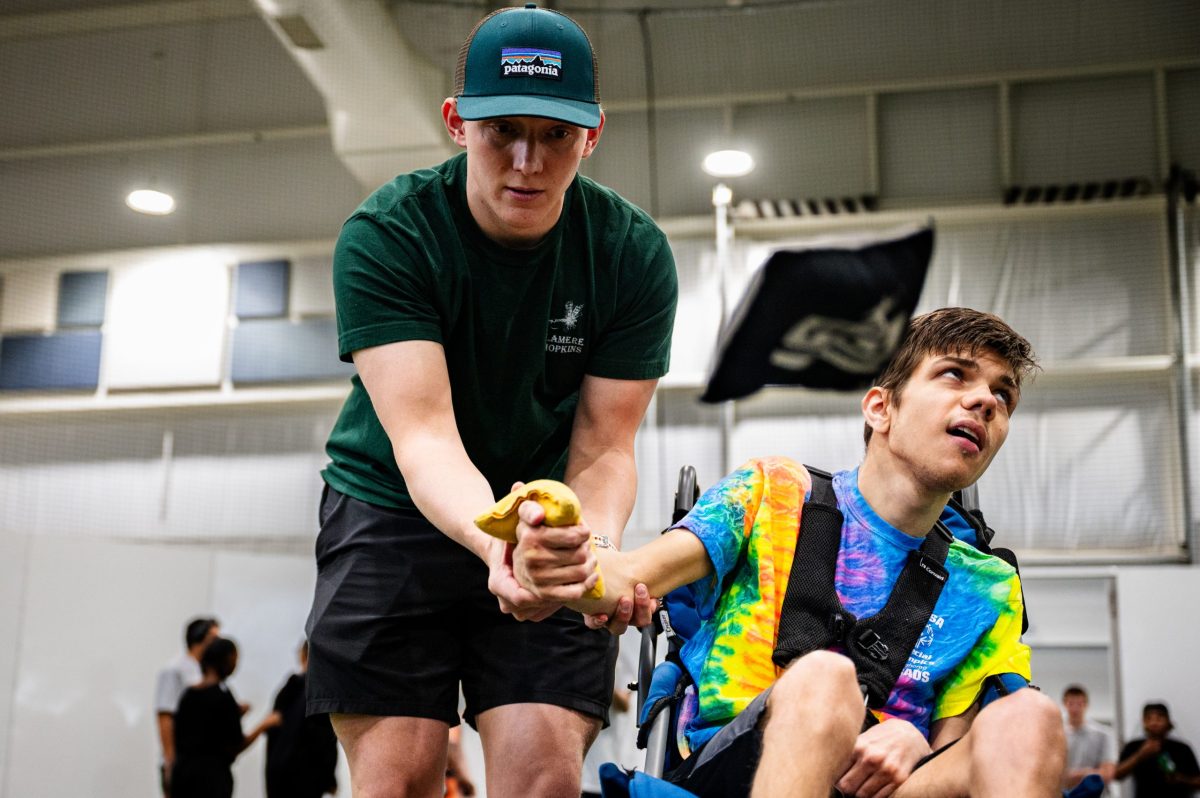 Hayden Crawford, left, helps his brother Holden Crawford play cornhole during a Special Olympics Unified Cornhole Tournament at Tulsa's Nathan Hale High School March 26, 2026. They are two of six brothers who are all athletes. "I wouldn't miss it for the world," Hayden said of the competition with his brother.