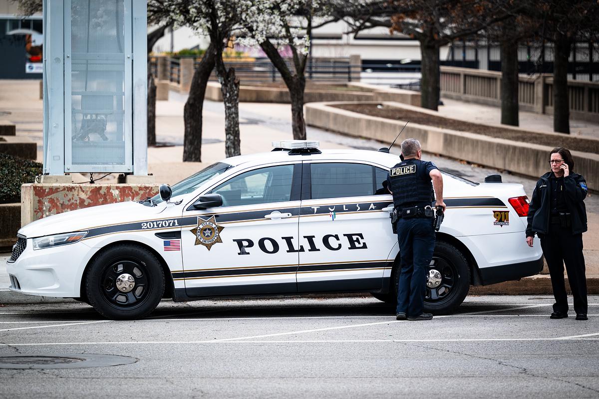 Two Tulsa Police Officers stand next to a patrol car  on Thursday, March 5, 2026.
