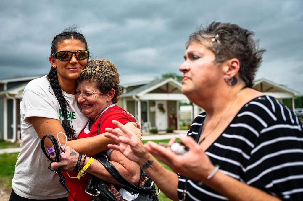 From left: Support specialist Elizabeth Maccoy hugs Angela Moore while they listen to LeAnn Greer speaks about her addiction story at Eden Village of Tulsa, April 17, 2026. 