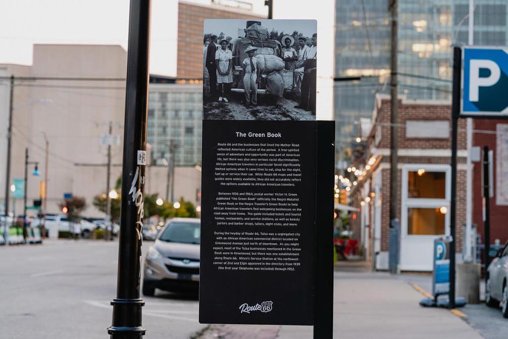 The Green Book historic marker for Mince's Service Station sits near the corner of 2nd Street and Elgin. The travel guide listed businesses around the country that were safe and welcoming to Black travelers.