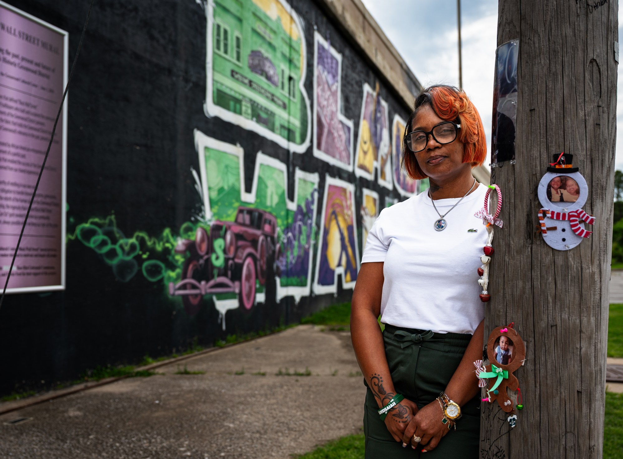 Angel Spears poses for a portrait next to her son Isaiah Knight’s memorial in Greenwood on Wednesday, April 29, 2026. Knight, 22, was shot and killed June 21, 2025. A small memorial was created for Isaiah near the Black Wall Street mural at the back of the Greenwood Cultural Center parking lot.