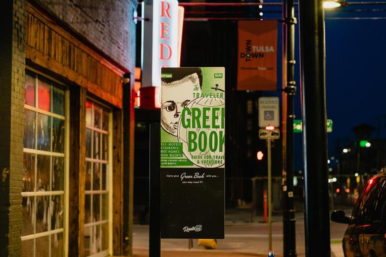 The Green Book historic marker for Mince's Service Station sits near the corner of 2nd Street and Elgin. The travel guide listed businesses around the country that were safe and welcoming to Black travelers.