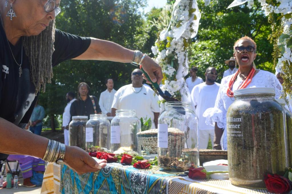Longtime north Tulsa activist Mama Joyce Smith-Williams pours soil into a jar during a May 31, 2026, ceremony in remembrance of Mother Viola Fletcher, a massacre survivor who died in 2025 at age 111.