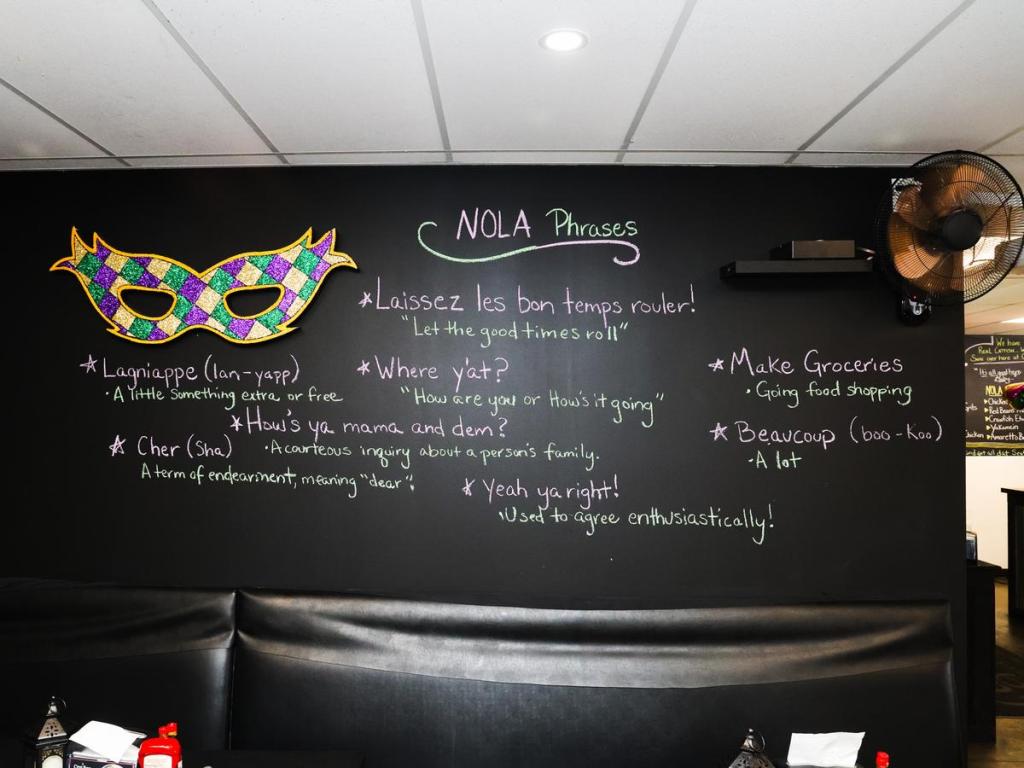 Popular New Orleans phrases appear on a dining room wall inside C’est Bon Kitchen & Libations, 1717 N. Peoria Ave. Suite 7, on June 3, 2026. 