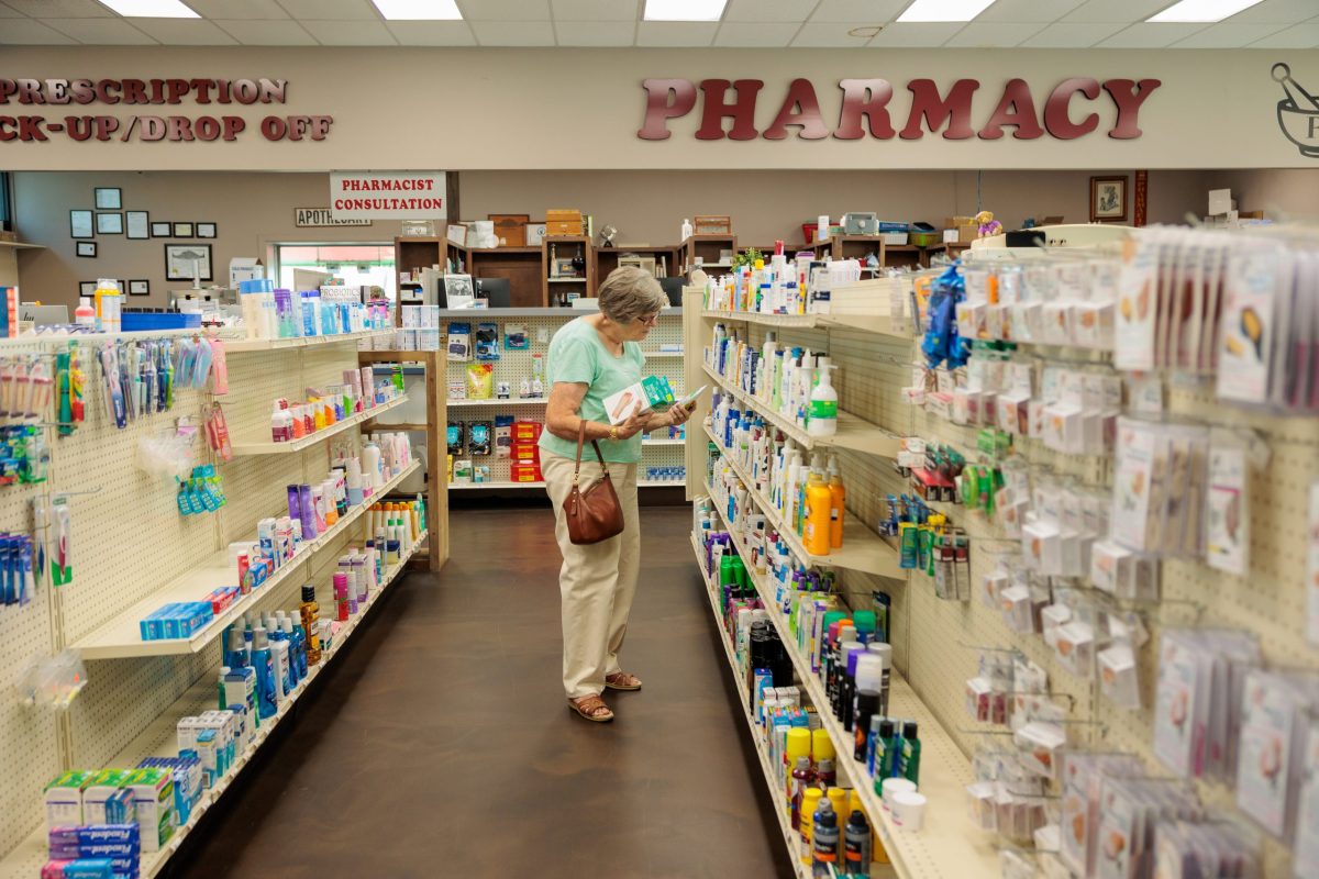 woman stands in pharmacy aisle