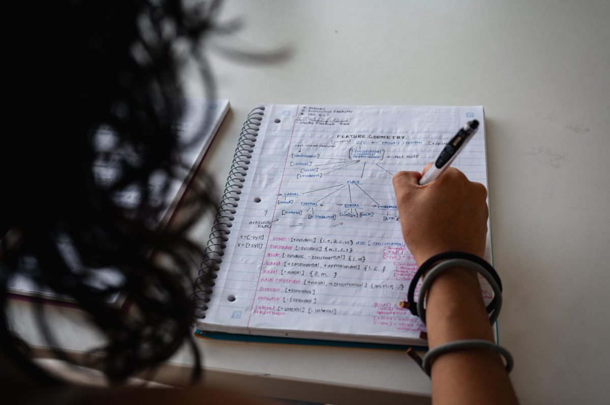 Maria Reynolds, a former University of Oklahoma student who dropped out following the end of in-state tuition for students without legal status in the U.S., writes in her notebook Aug. 19, 2026. She is using a pseudonym for fear of deportation.