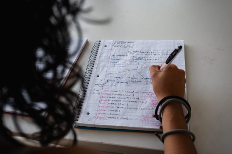 Maria Reynolds, a former University of Oklahoma student who dropped out following the end of in-state tuition for students without legal status in the U.S., writes in her notebook Aug. 19, 2026. She is using a pseudonym for fear of deportation.